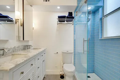 a bathroom with a granite countertop sink toilet and shower