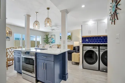 a kitchen with a sink a stove and chairs