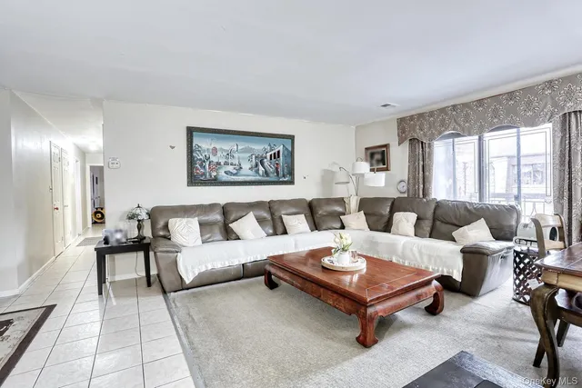 a living room with furniture potted plant and a large window
