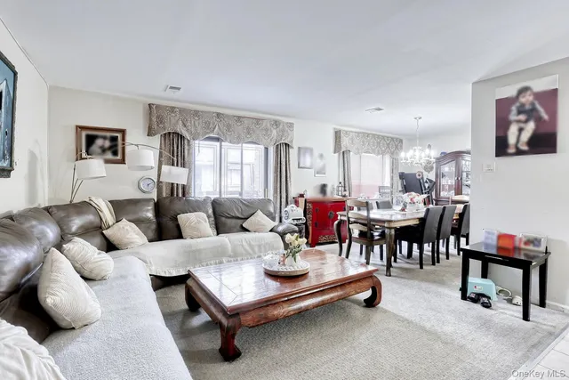 a living room with furniture and a dining table with kitchen view