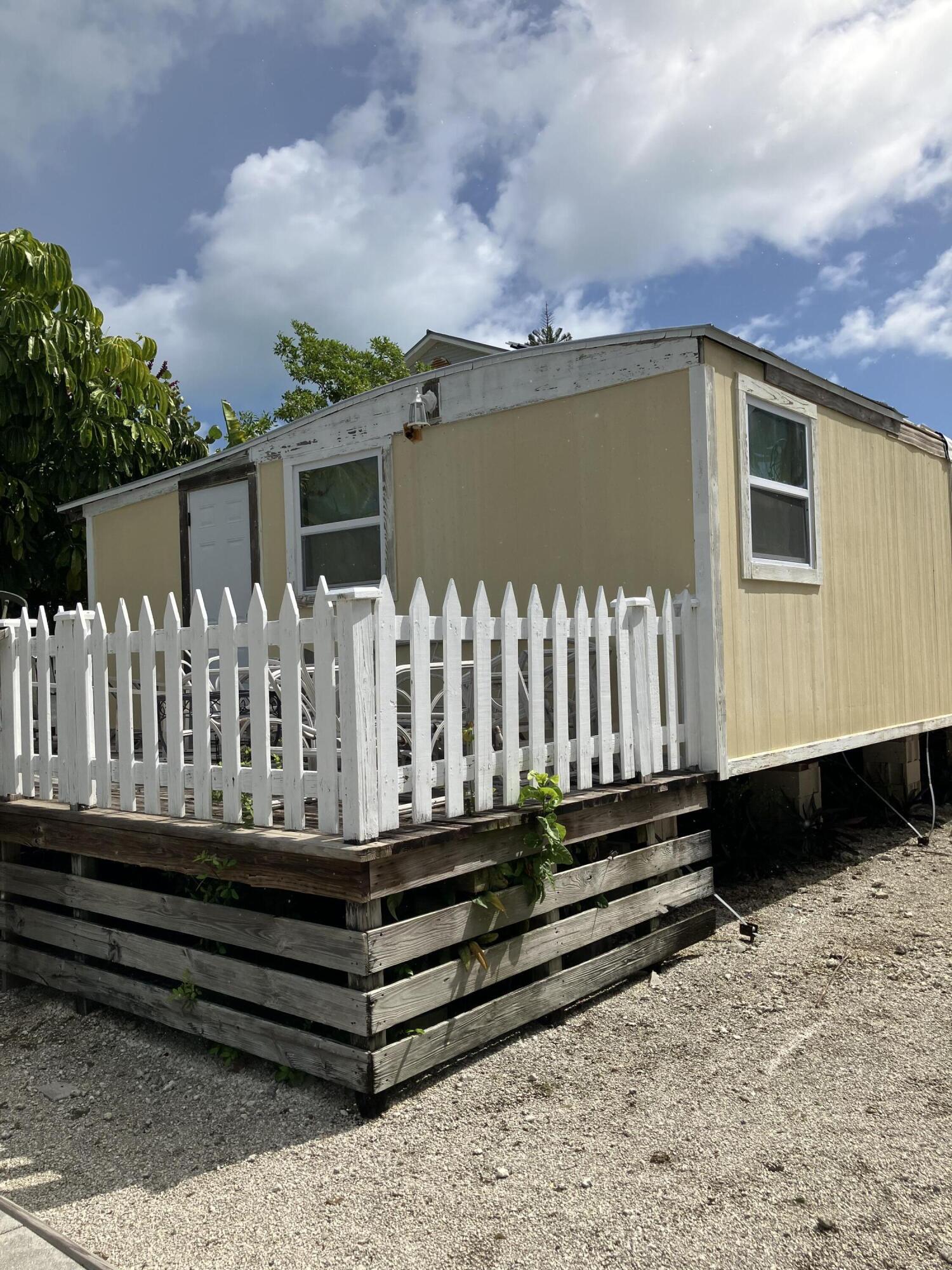 330 Spica Lane Key West, FL 33040 - Photo 3 of 6 a front view of a house with a wooden fence