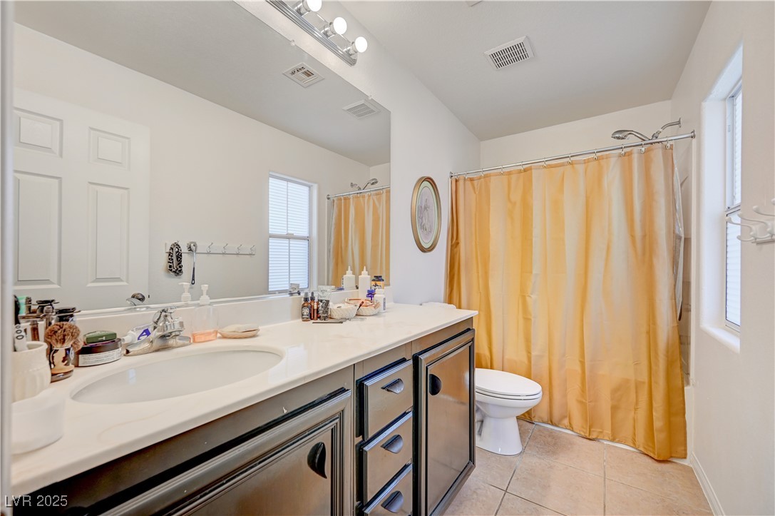 1168 Paradise River Road Henderson, NV 89002 - Photo 23 of 29 Bathroom with vanity, light tile patterned flooring, and shower / tub combo with curtain