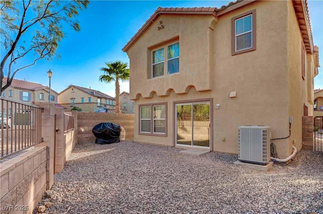 1168 Paradise River Road Henderson, NV 89002 - Photo 28 of 29 Rear view of property featuring a fenced backyard, stucco siding, and a tiled roof