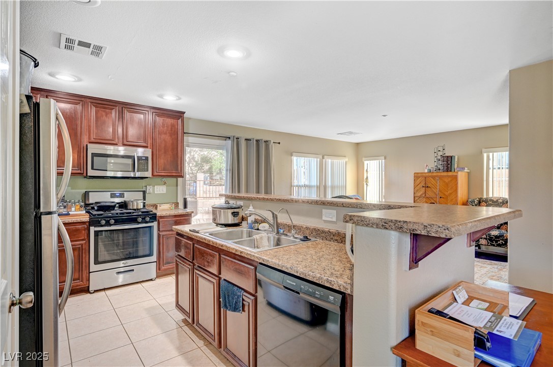 1168 Paradise River Road Henderson, NV 89002 - Photo 4 of 29 Kitchen featuring appliances with stainless steel finishes, a center island with sink, light countertops, and a breakfast bar area