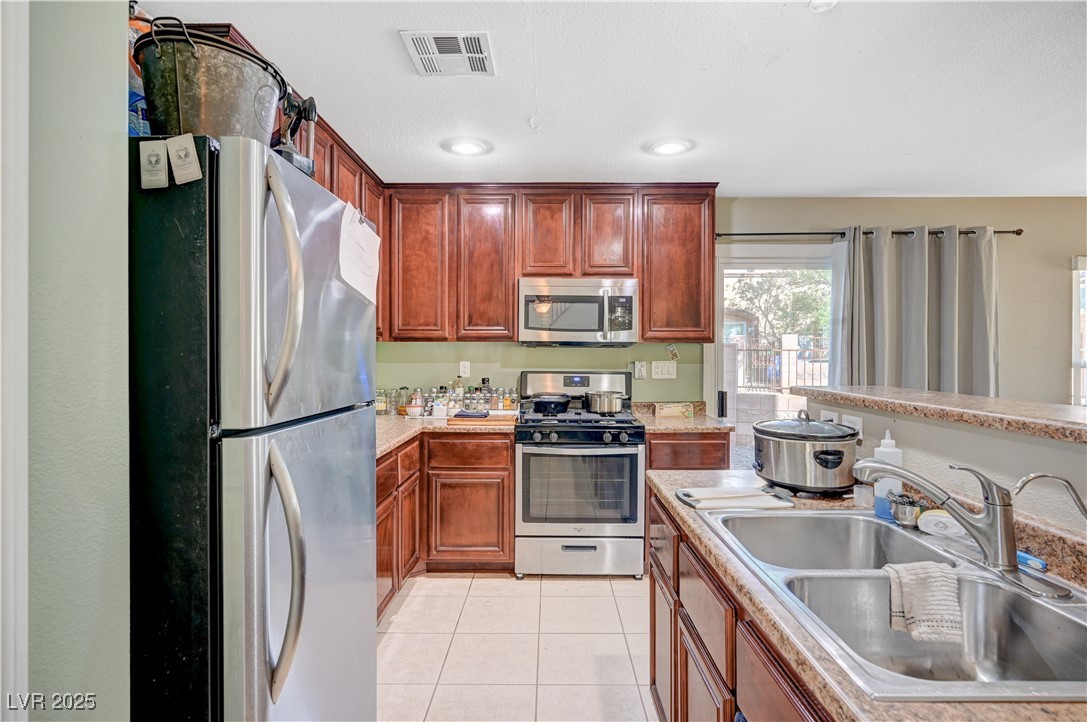 1168 Paradise River Road Henderson, NV 89002 - Photo 5 of 29 Kitchen with appliances with stainless steel finishes, light countertops, light tile patterned floors, and recessed lighting
