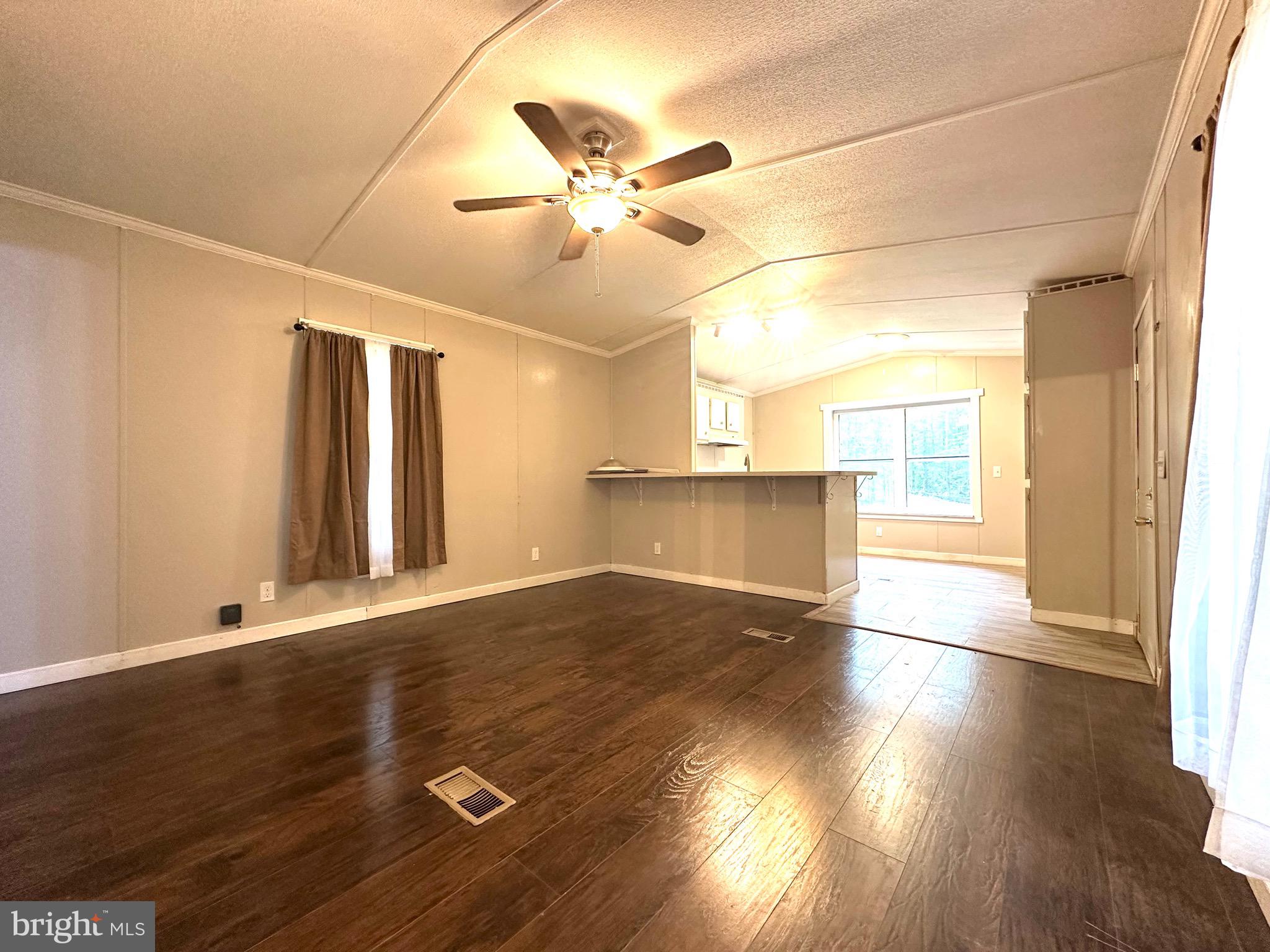 606 Dogwood Acres Road Bumpass, VA 23024 - Photo 3 of 20 a view of an empty room with wooden floor and a window