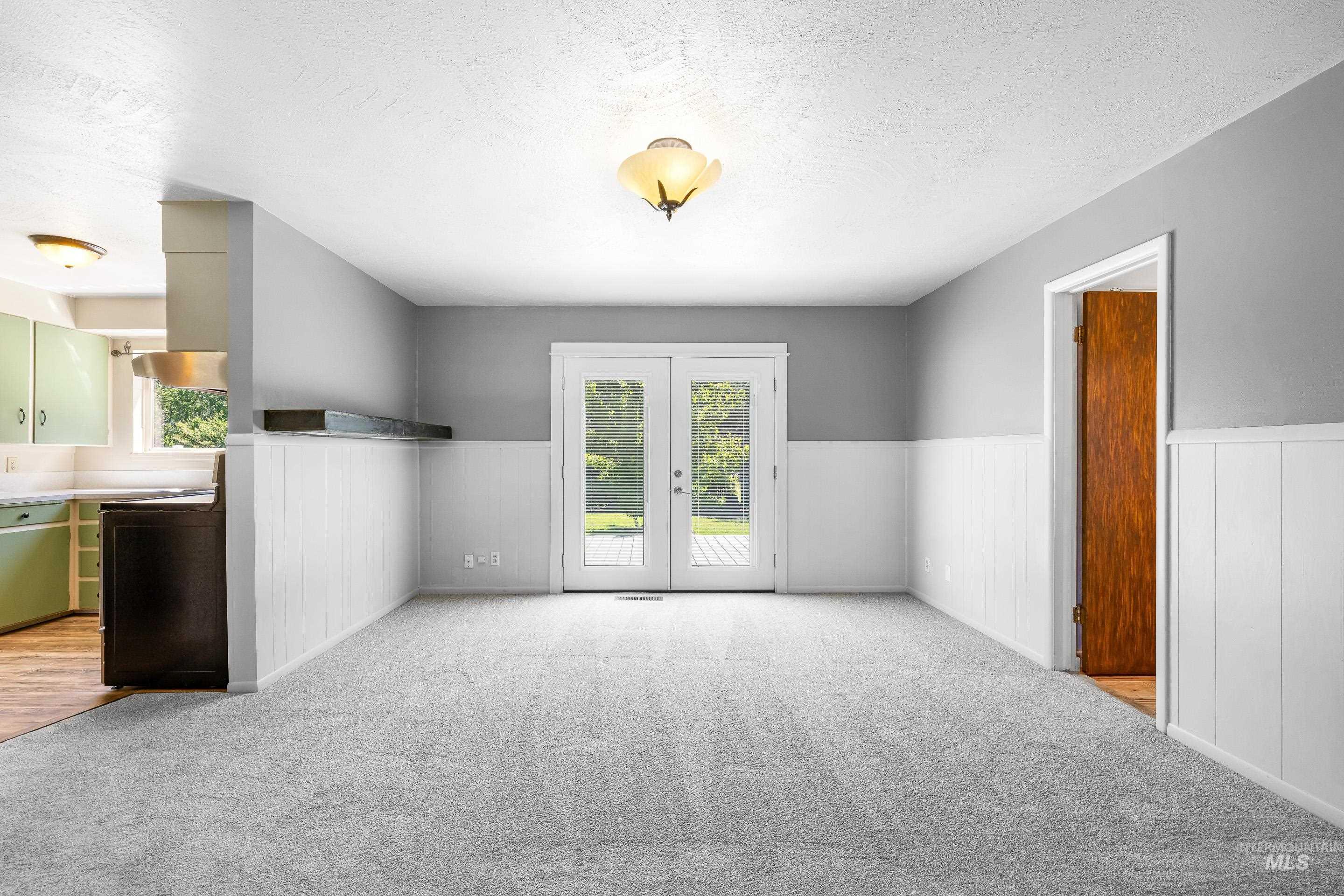 708 South Phillippi Street Boise, ID 83705 - Photo 7 of 25 Gray carpeted room with white wainscoting and light gray walls