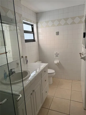 a bathroom with a granite countertop sink a toilet and a mirror