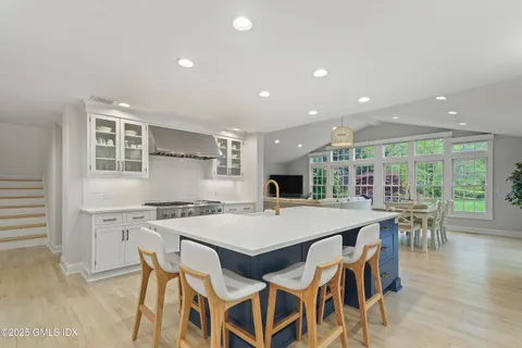 a kitchen with stainless steel appliances kitchen island granite countertop a stove and a refrigerator