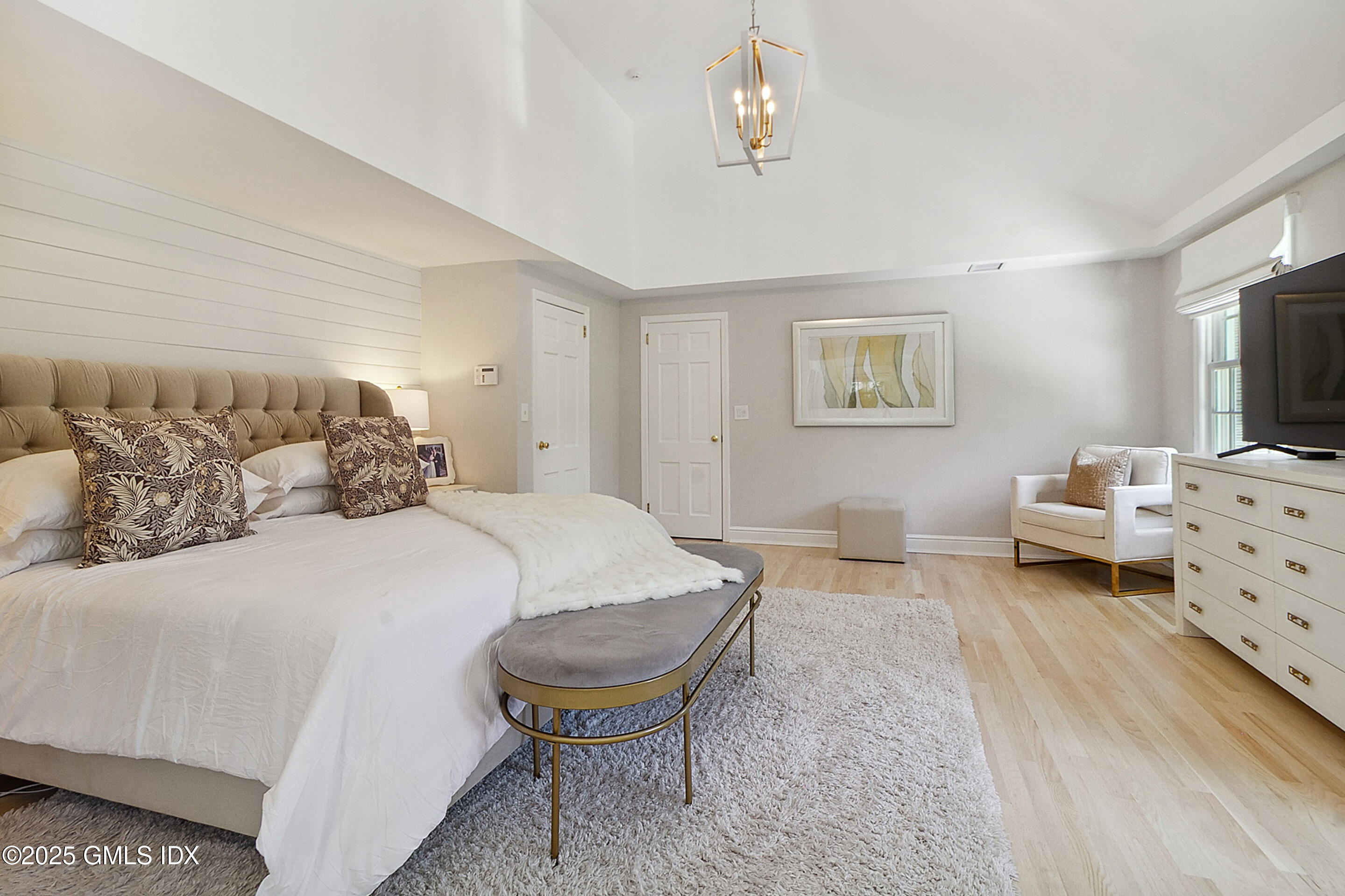 17 Will Merry Lane Greenwich, CT 06831 - Photo 29 of 49 a bedroom with a bed and a chandelier