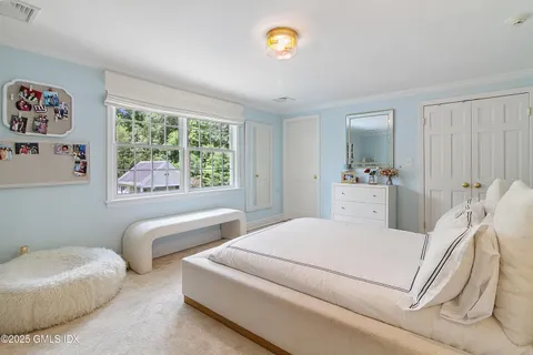 a bedroom with bed and a large window