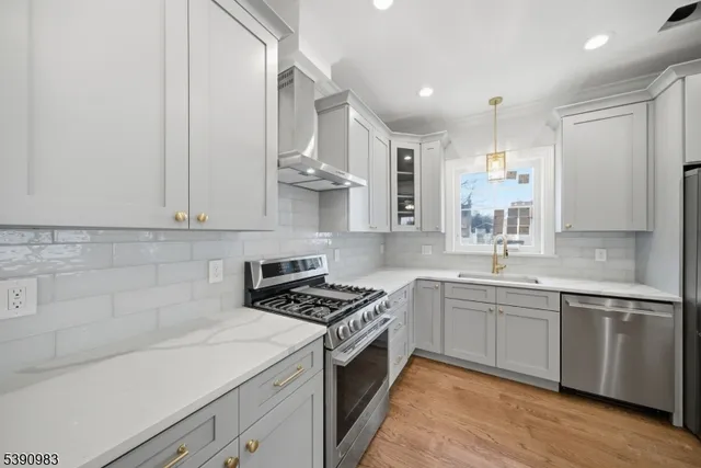 a kitchen with stainless steel appliances a sink stove and cabinets