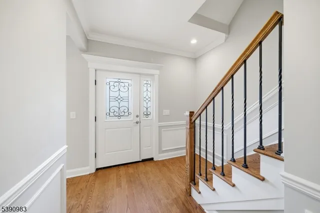 a view of front door with wooden floor and stairs