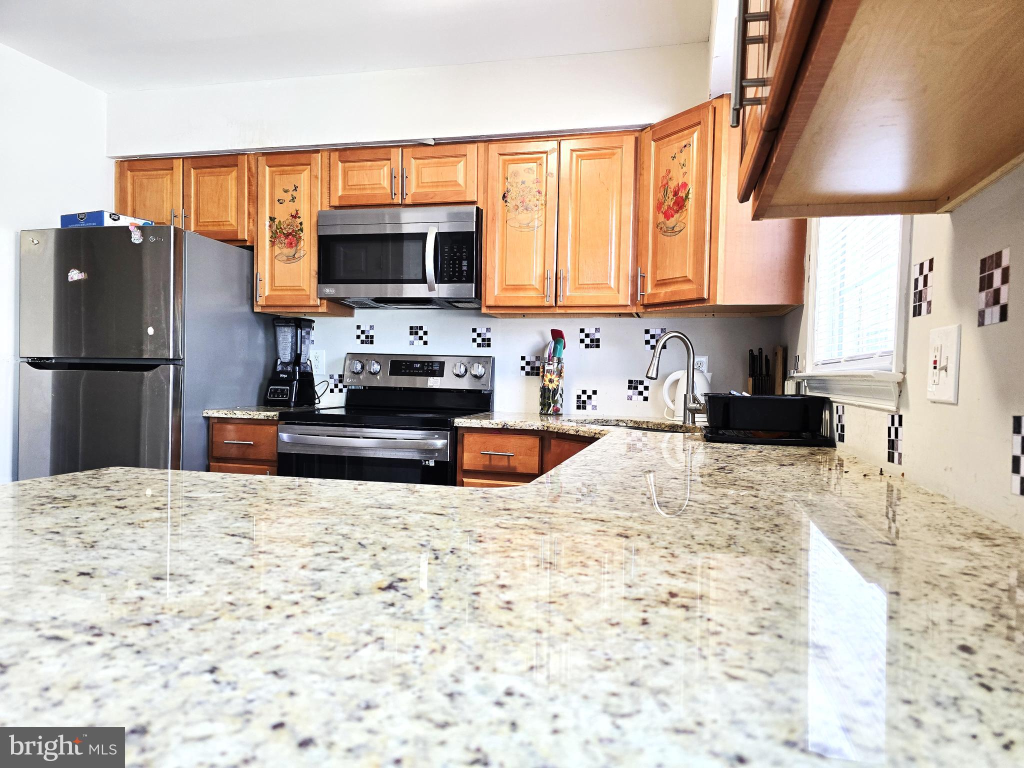 3 Arnold Place Newark, DE 19702 - Photo 3 of 28 a kitchen with granite countertop a refrigerator and a stove top oven
