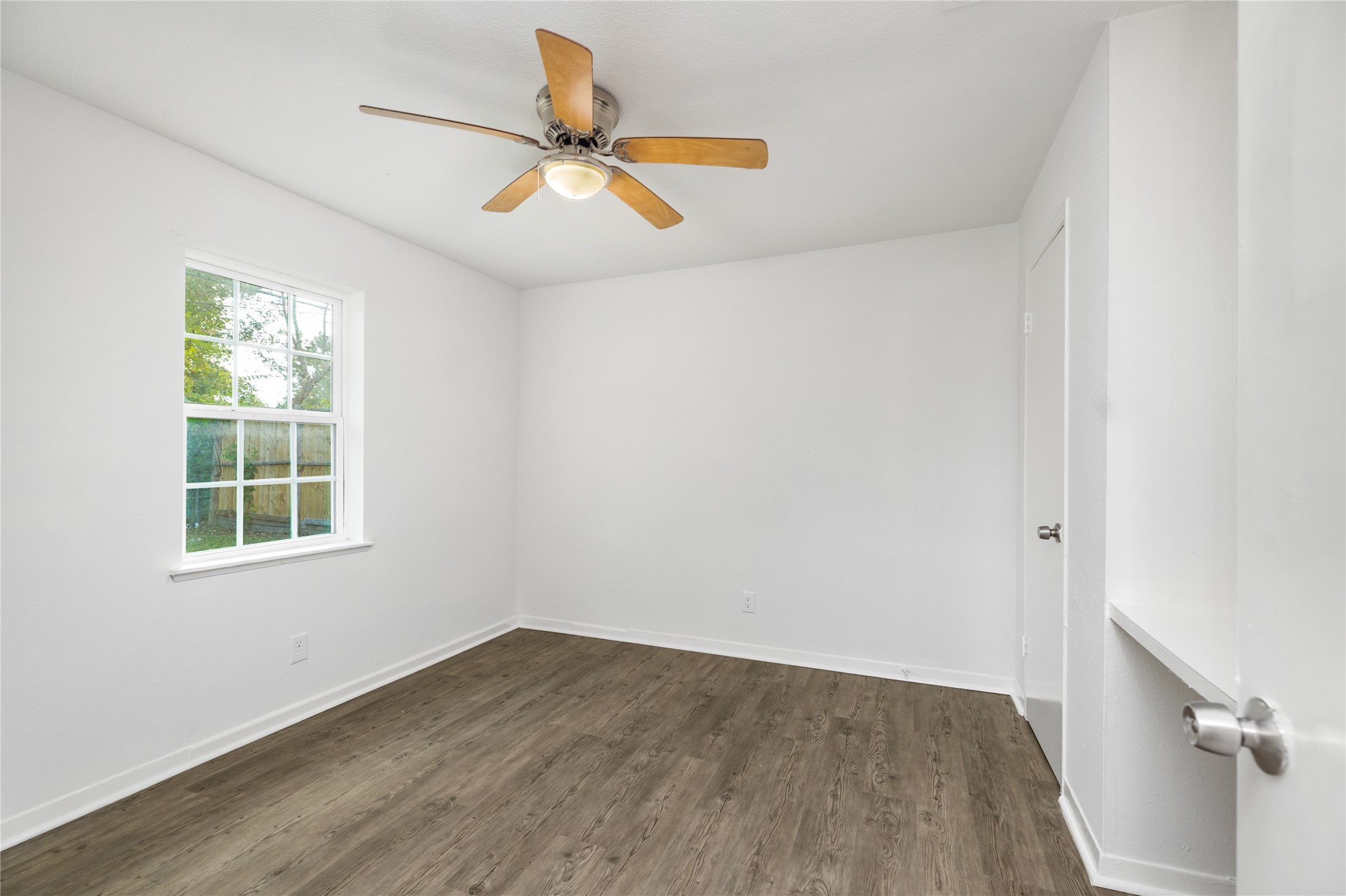 9322 Nyssa Street Houston, TX 77078 - Photo 25 of 34 an empty room with wooden floor fan and windows