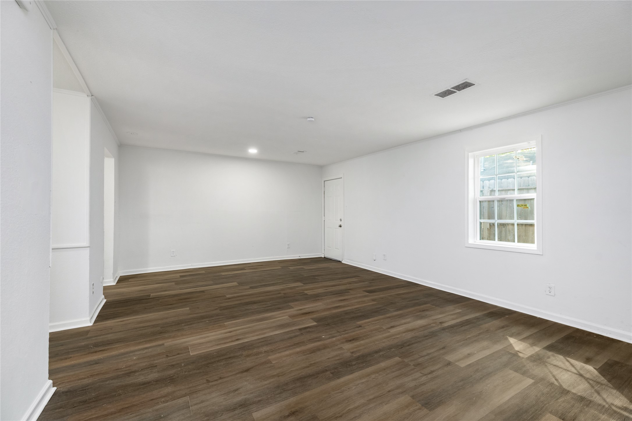 9322 Nyssa Street Houston, TX 77078 - Photo 3 of 34 a view of an empty room with wooden floor and a window