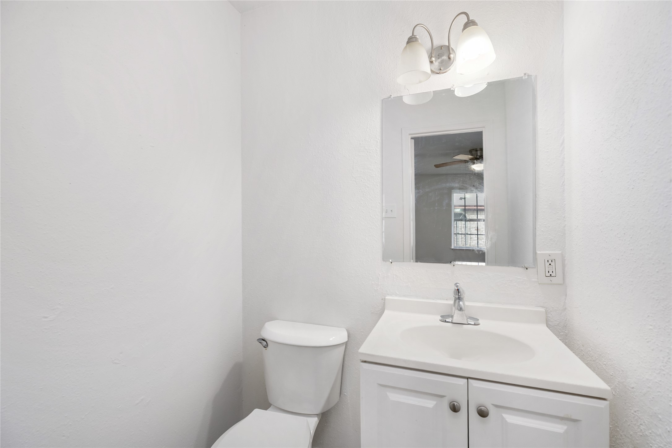 9322 Nyssa Street Houston, TX 77078 - Photo 32 of 34 a bathroom with a sink a toilet and mirror