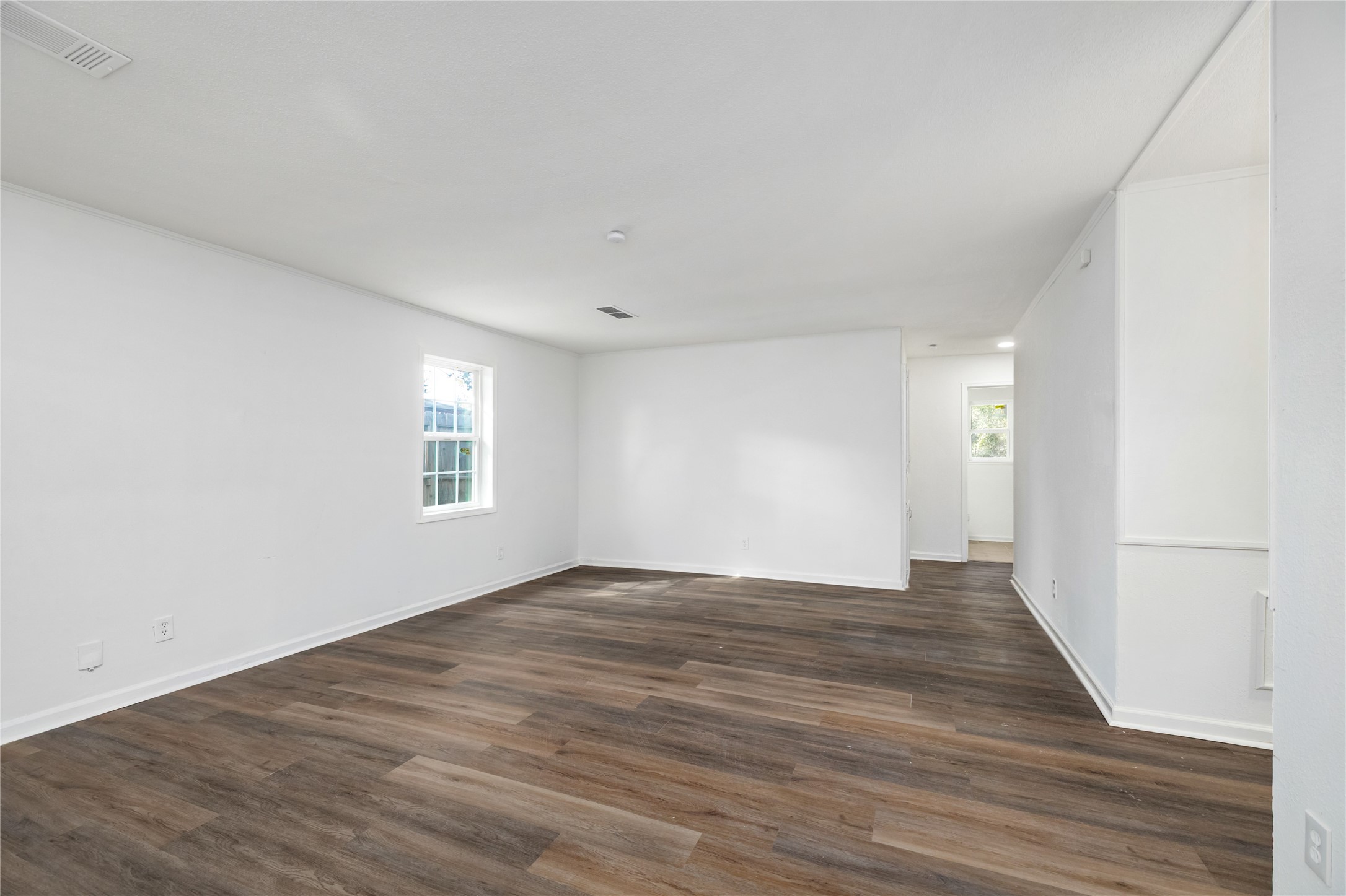 9322 Nyssa Street Houston, TX 77078 - Photo 5 of 34 a view of an empty room with wooden floor and a window