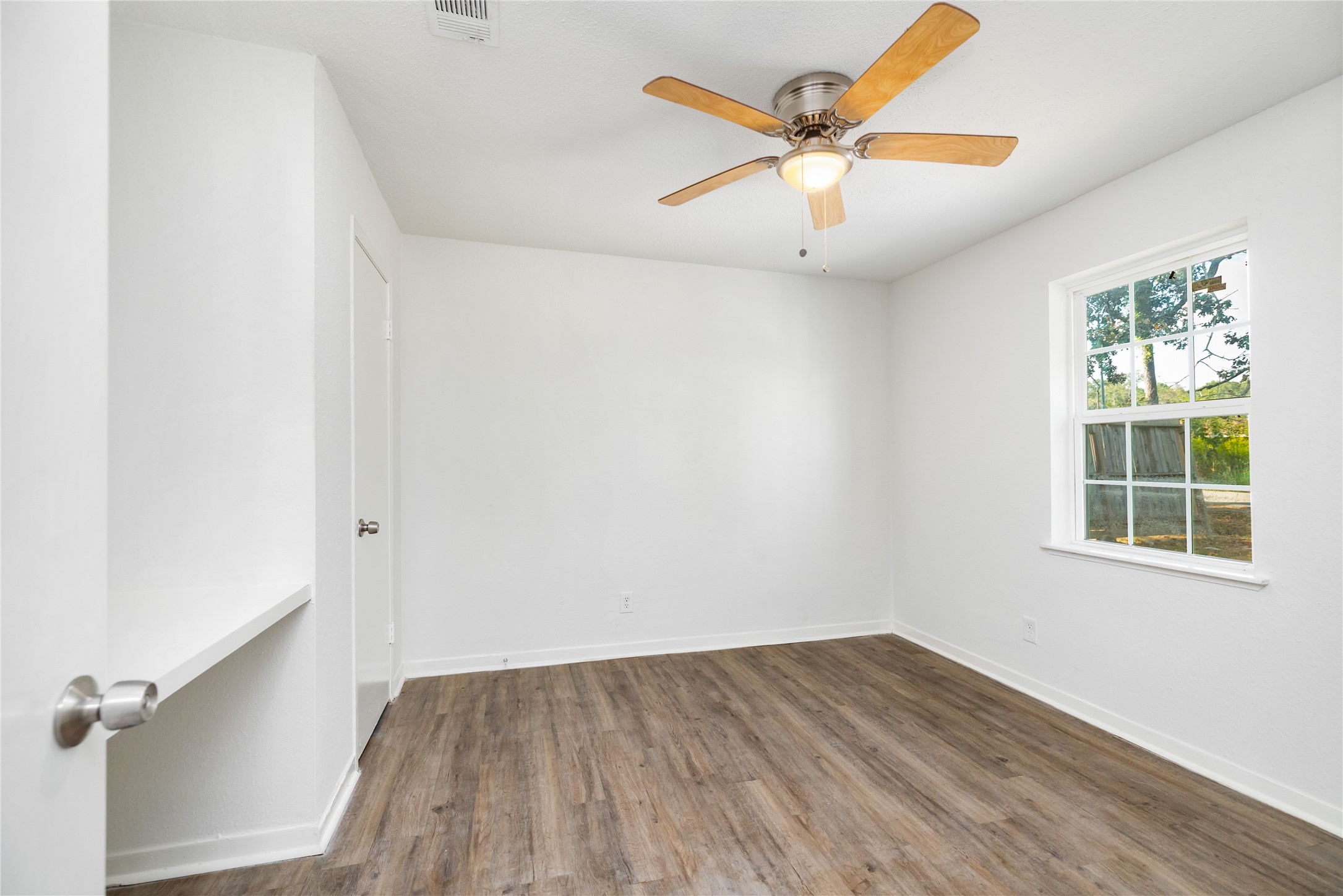 9322 Nyssa Street Houston, TX 77078 - Photo 10 of 34 an empty room with wooden floor fan and windows