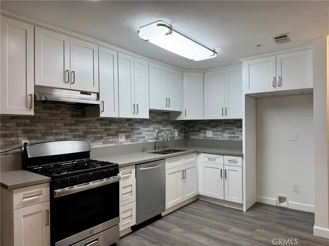 a kitchen with stainless steel appliances granite countertop a stove a sink and a refrigerator