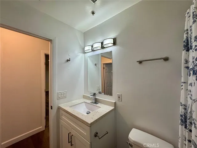 a bathroom with a sink a toilet a mirror and shower