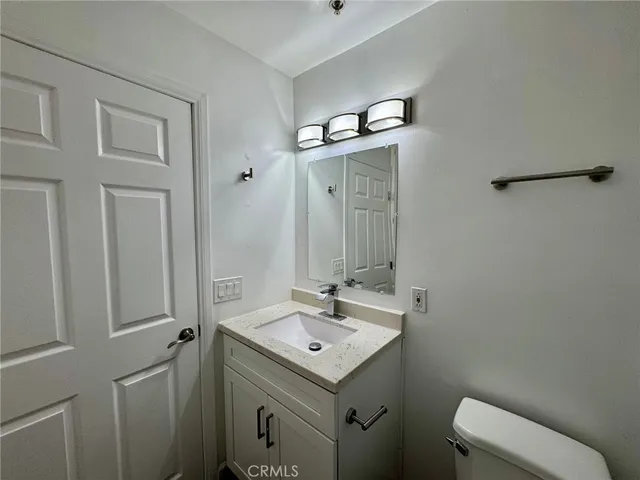 a bathroom with a sink a toilet and mirror