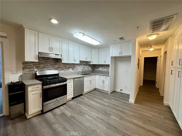 a kitchen with granite countertop a refrigerator and a stove top oven