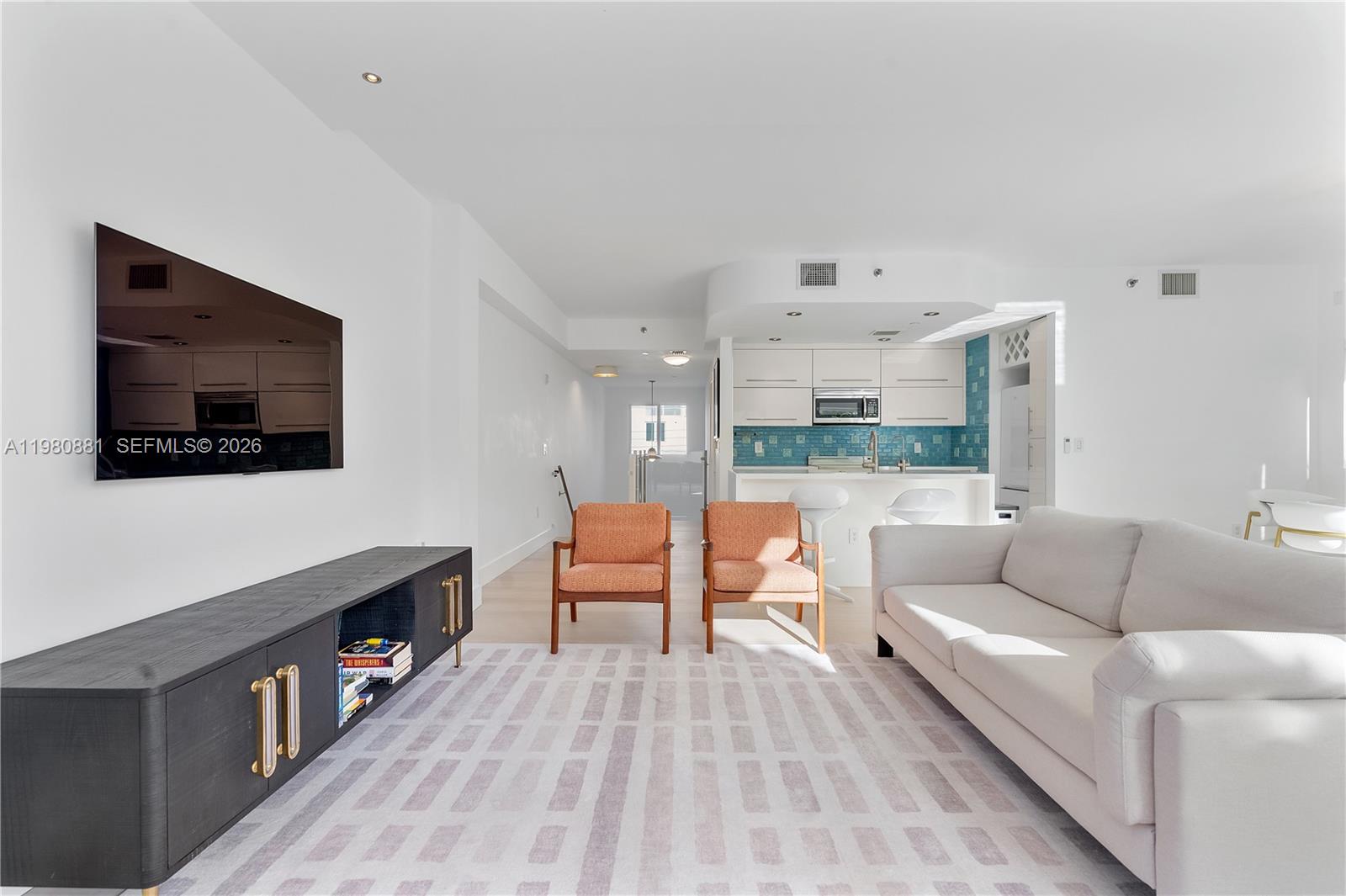 828 3rd Street, Unit 314 Miami Beach, FL 33139 - Photo 4 of 28 a living room with furniture and a flat screen tv
