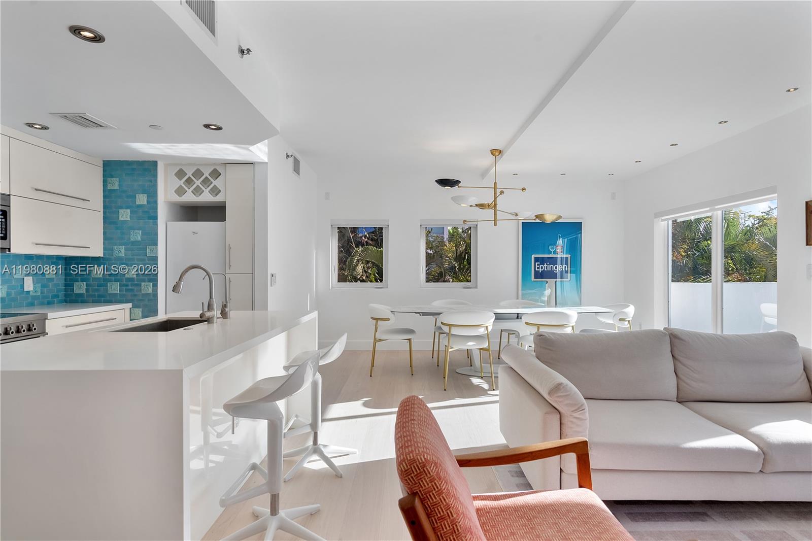 828 3rd Street, Unit 314 Miami Beach, FL 33139 - Photo 6 of 28 a living room with furniture a large window and a chandelier