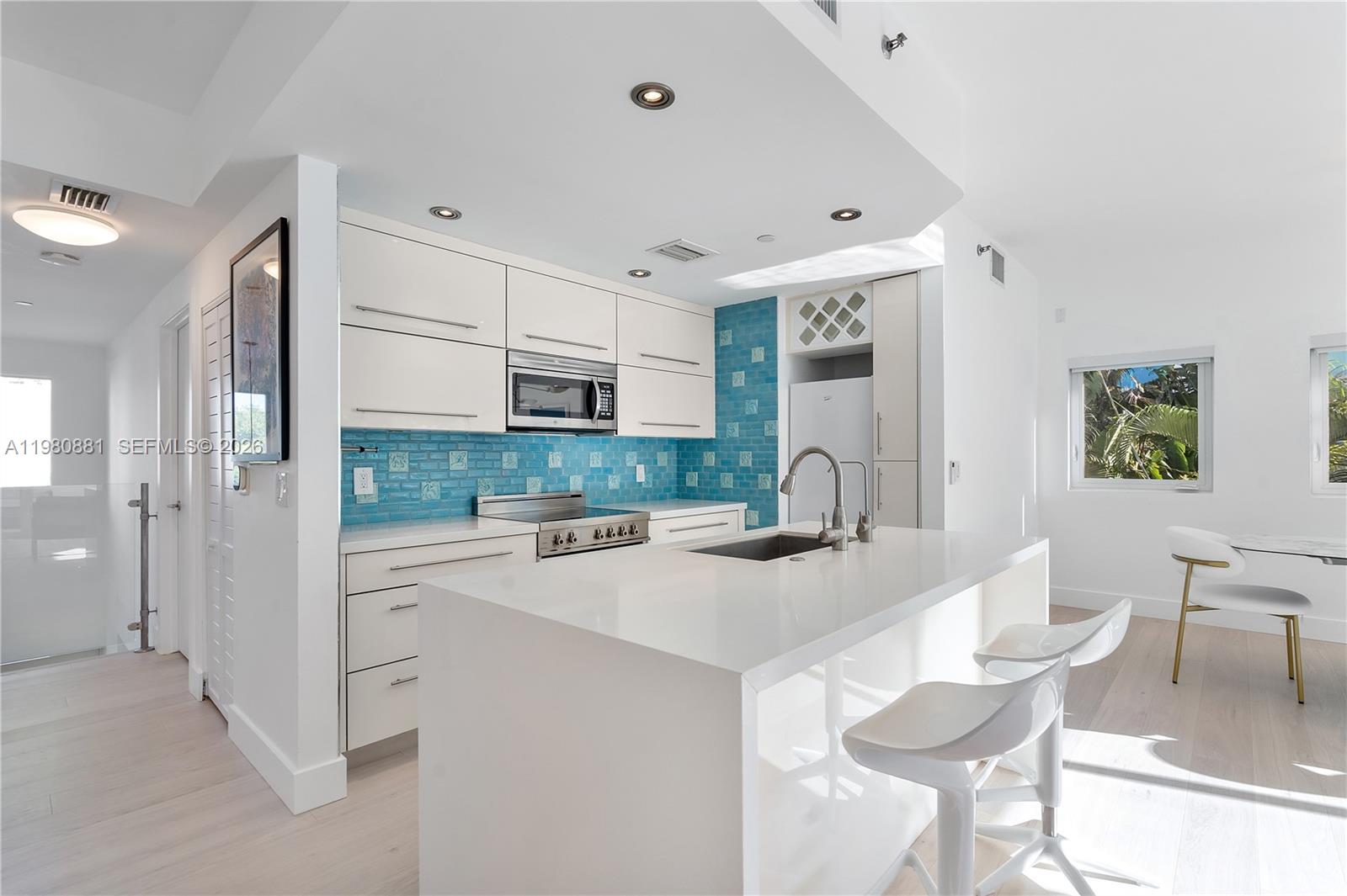 828 3rd Street, Unit 314 Miami Beach, FL 33139 - Photo 7 of 28 a kitchen with kitchen island a stove a table and chairs in it