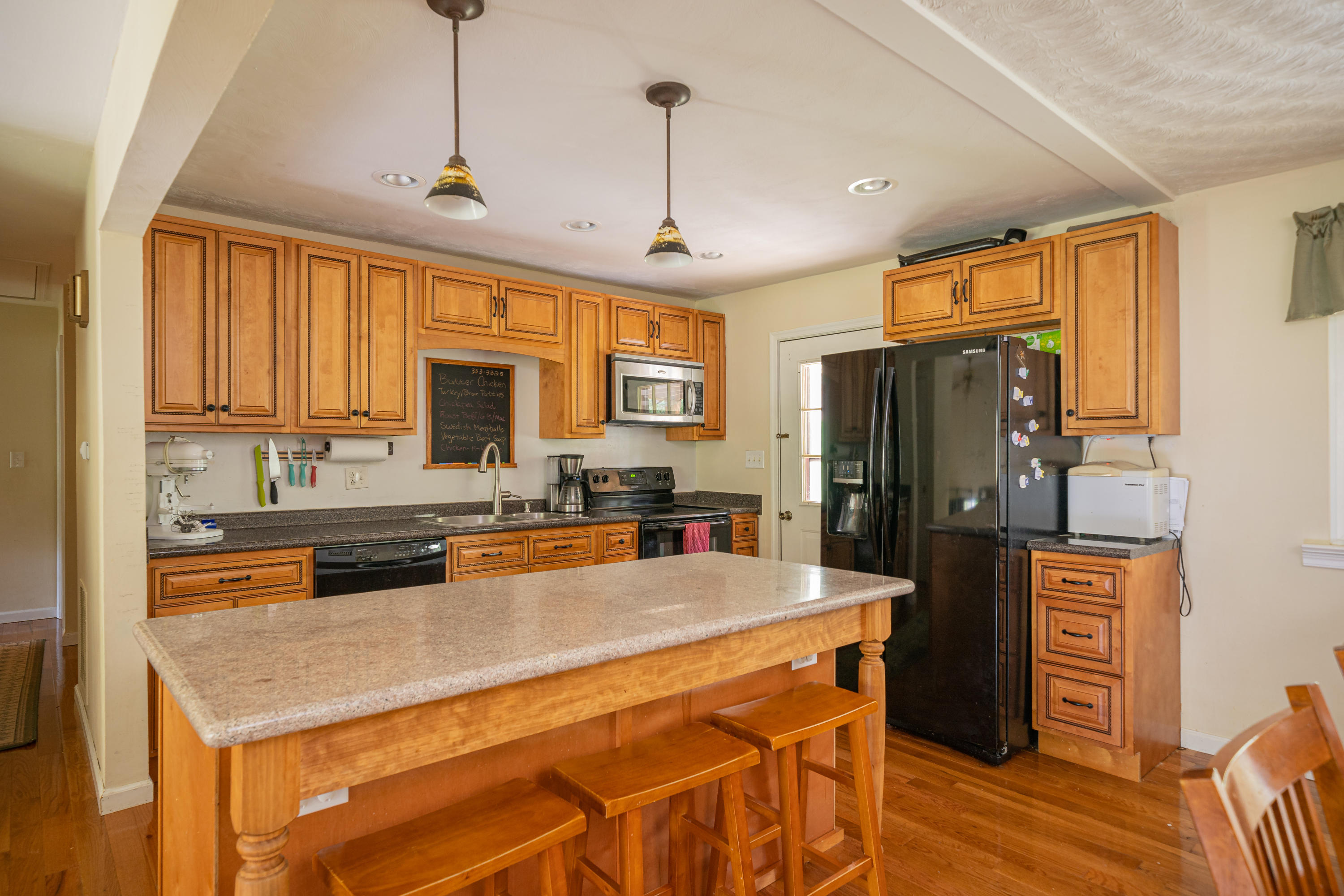 437 Pin Oak Drive Blue Ridge, VA 24064 - Photo 9 of 24 a kitchen with stainless steel appliances granite countertop a refrigerator a stove top oven a sink dishwasher and wooden cabinets with wooden floor