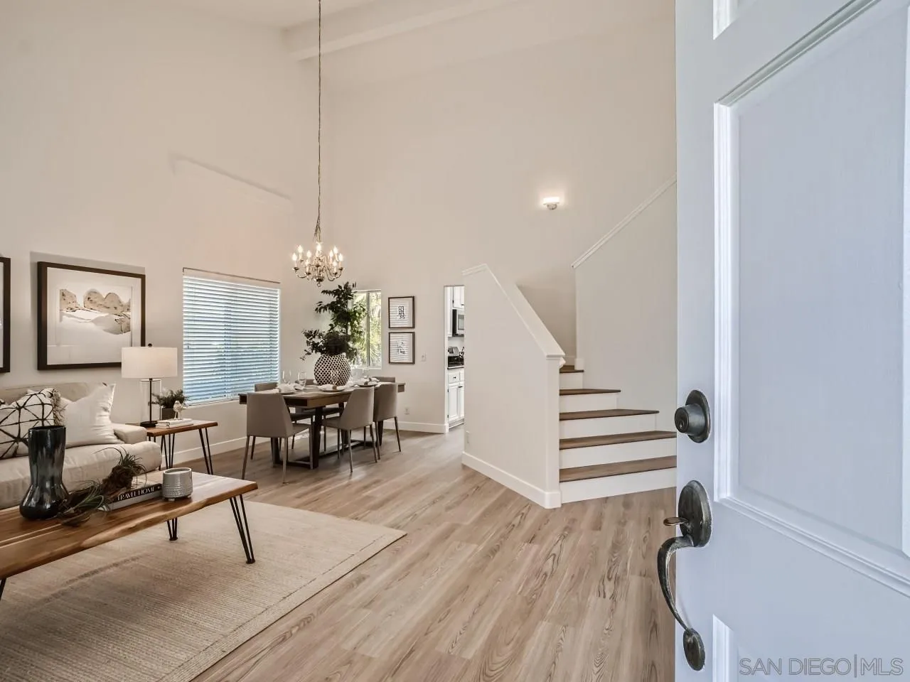 8515 Mesa Heights Road Santee, CA 92071 - Photo 4 of 28 a living room with couches chandelier and a dining table with wooden floor