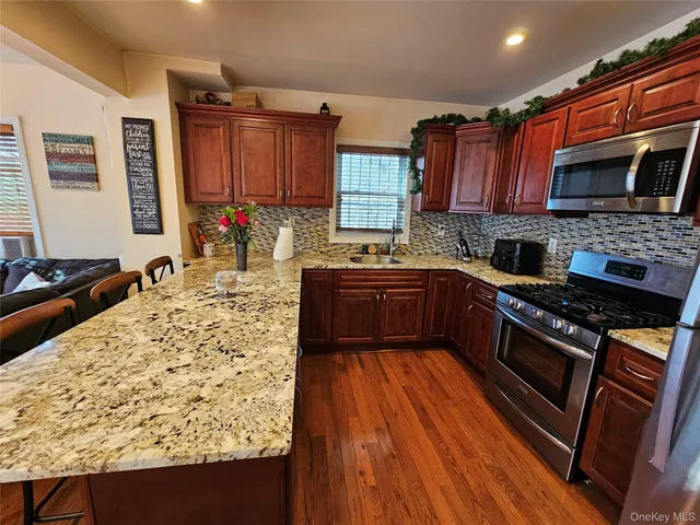 a kitchen with stainless steel appliances granite countertop a stove sink and cabinets