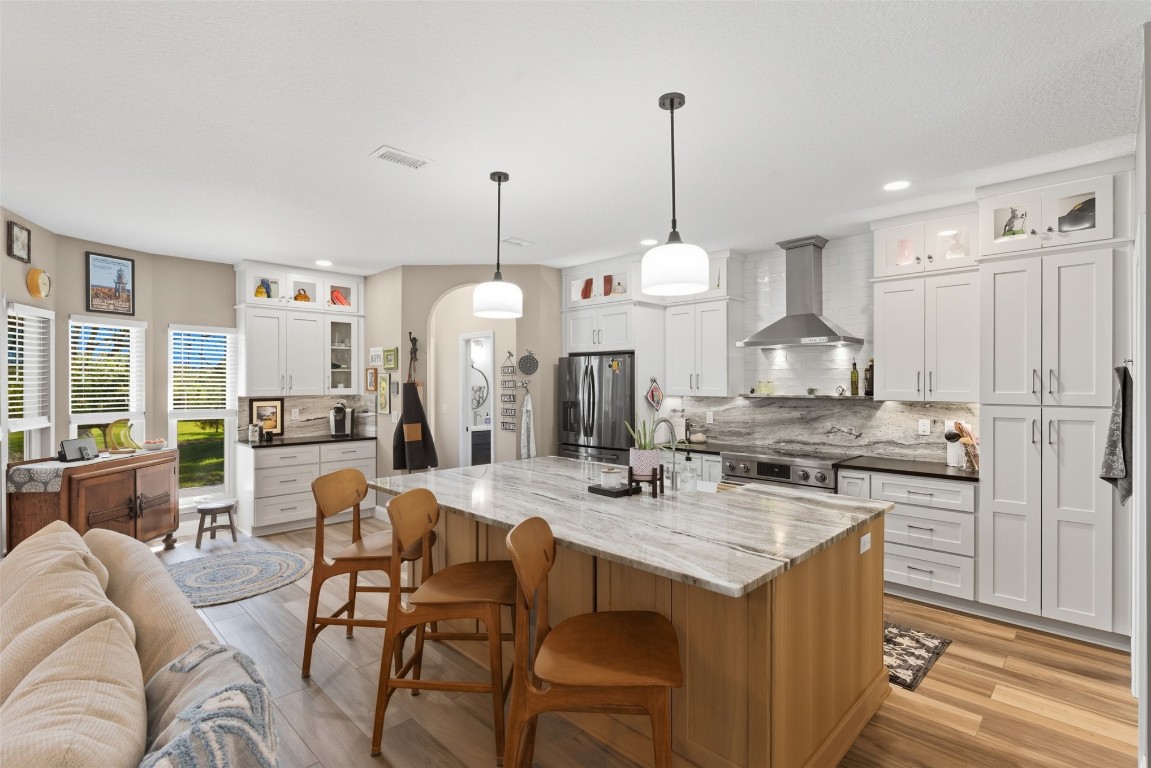 1250 Gum Leaf Road Jacksonville, FL 32226 - Photo 19 of 50 a kitchen with stainless steel appliances kitchen island granite countertop a stove a sink a oven a dining table and chairs with wooden floor
