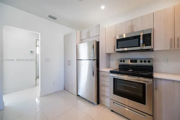 a kitchen with stainless steel appliances white cabinets white stove a refrigerator and a microwave