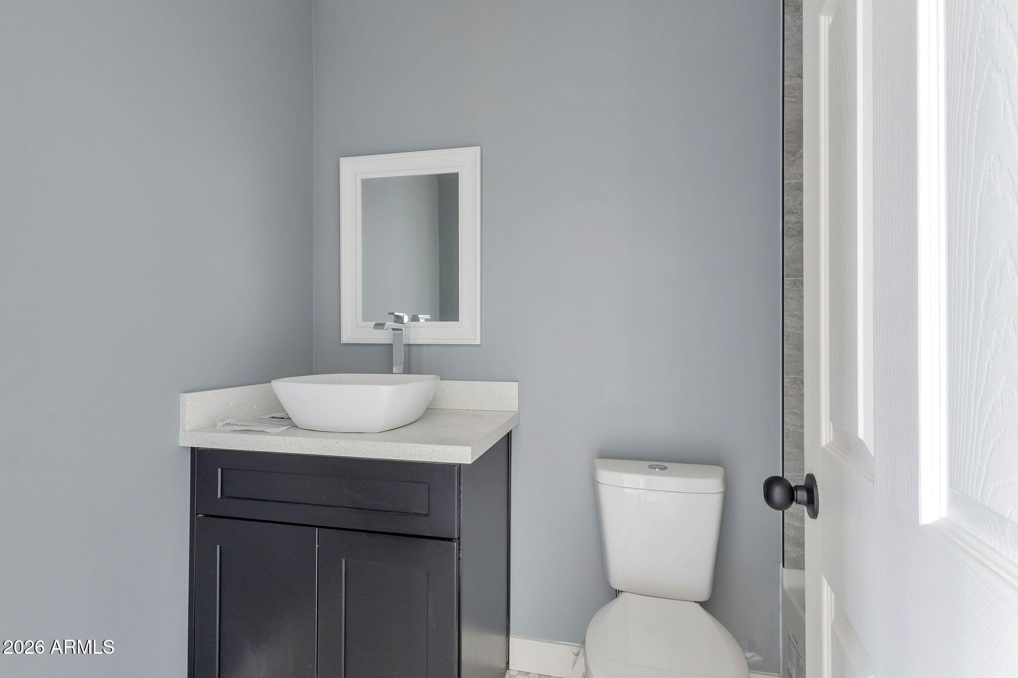 219 West Paseo Way Phoenix, AZ 85041 - Photo 12 of 14 a bathroom with a toilet sink and mirror