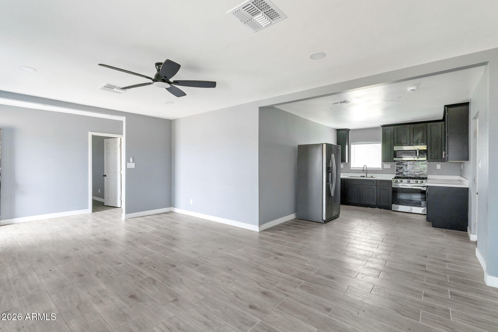 219 West Paseo Way Phoenix, AZ 85041 - Photo 4 of 14 a kitchen with stainless steel appliances kitchen island granite countertop a refrigerator and a sink