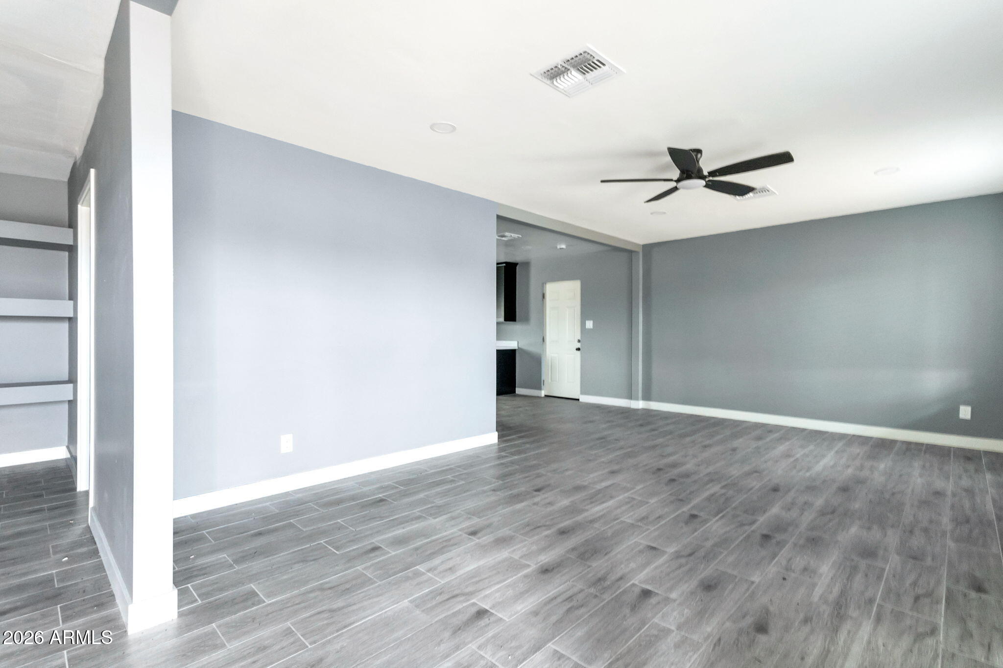 219 West Paseo Way Phoenix, AZ 85041 - Photo 5 of 14 a view of an empty room with wooden floor and a ceiling fan
