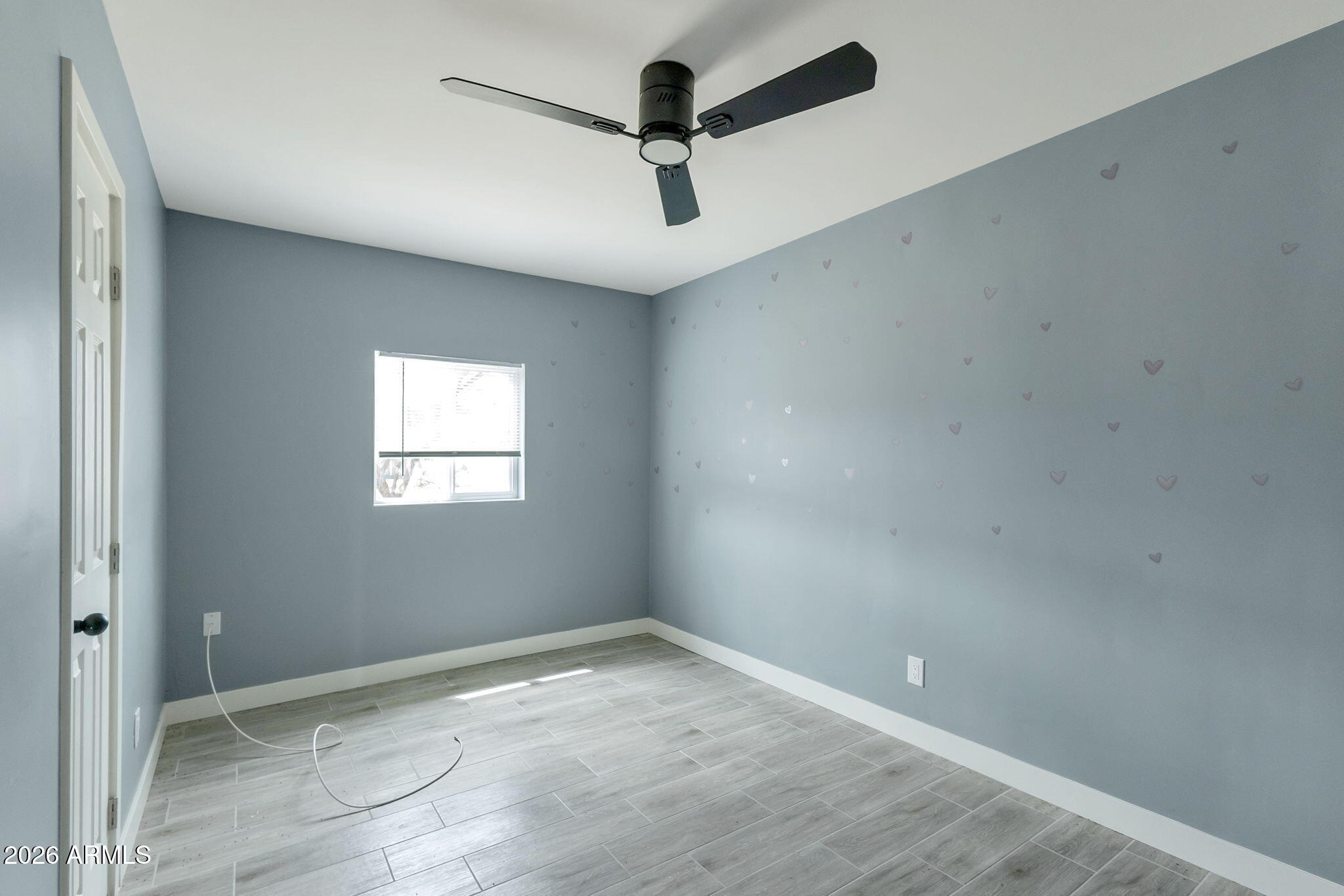 219 West Paseo Way Phoenix, AZ 85041 - Photo 9 of 14 an empty room with a ceiling fan and window