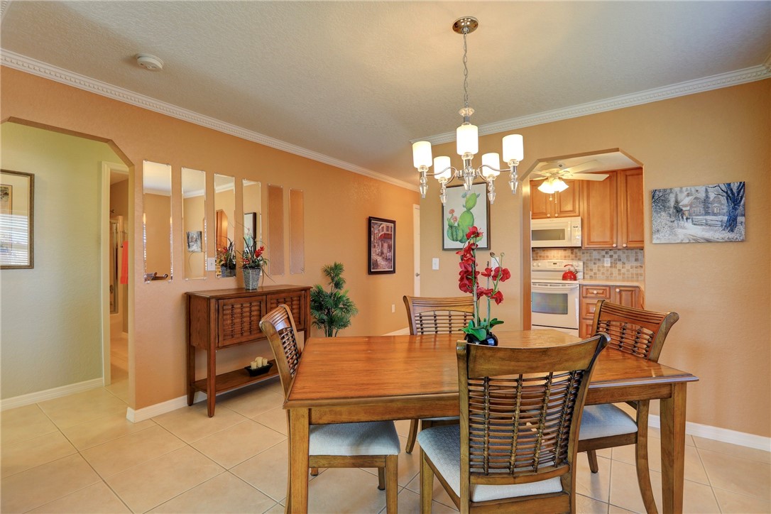 105 Spring Lake Court, Unit 207 Vero Beach, FL 32962 - Photo 16 of 34 a view of a dining room with furniture and chandelier
