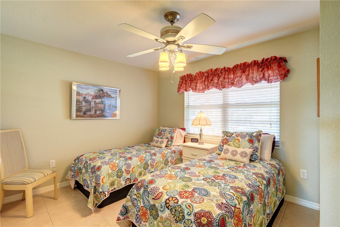 105 Spring Lake Court, Unit 207 Vero Beach, FL 32962 - Photo 17 of 34 a bedroom with a bed and a chandelier