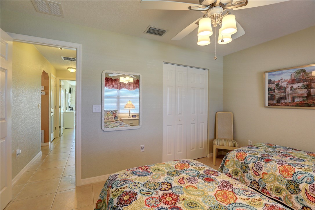 105 Spring Lake Court, Unit 207 Vero Beach, FL 32962 - Photo 18 of 34 a bedroom with a bed and a chandelier