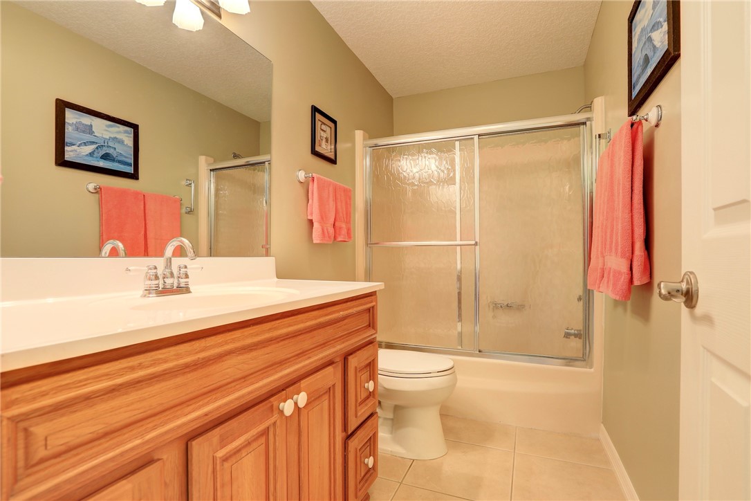 105 Spring Lake Court, Unit 207 Vero Beach, FL 32962 - Photo 19 of 34 a bathroom with a sink a toilet and shower
