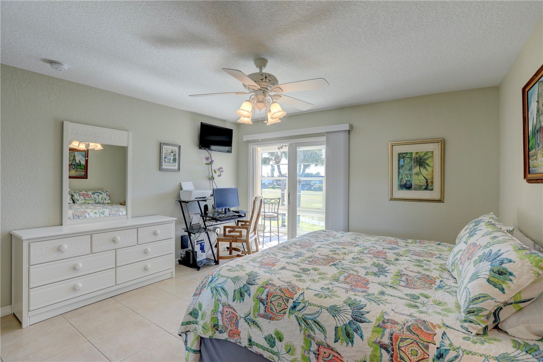 105 Spring Lake Court, Unit 207 Vero Beach, FL 32962 - Photo 20 of 34 a bedroom with a bed and a chandelier