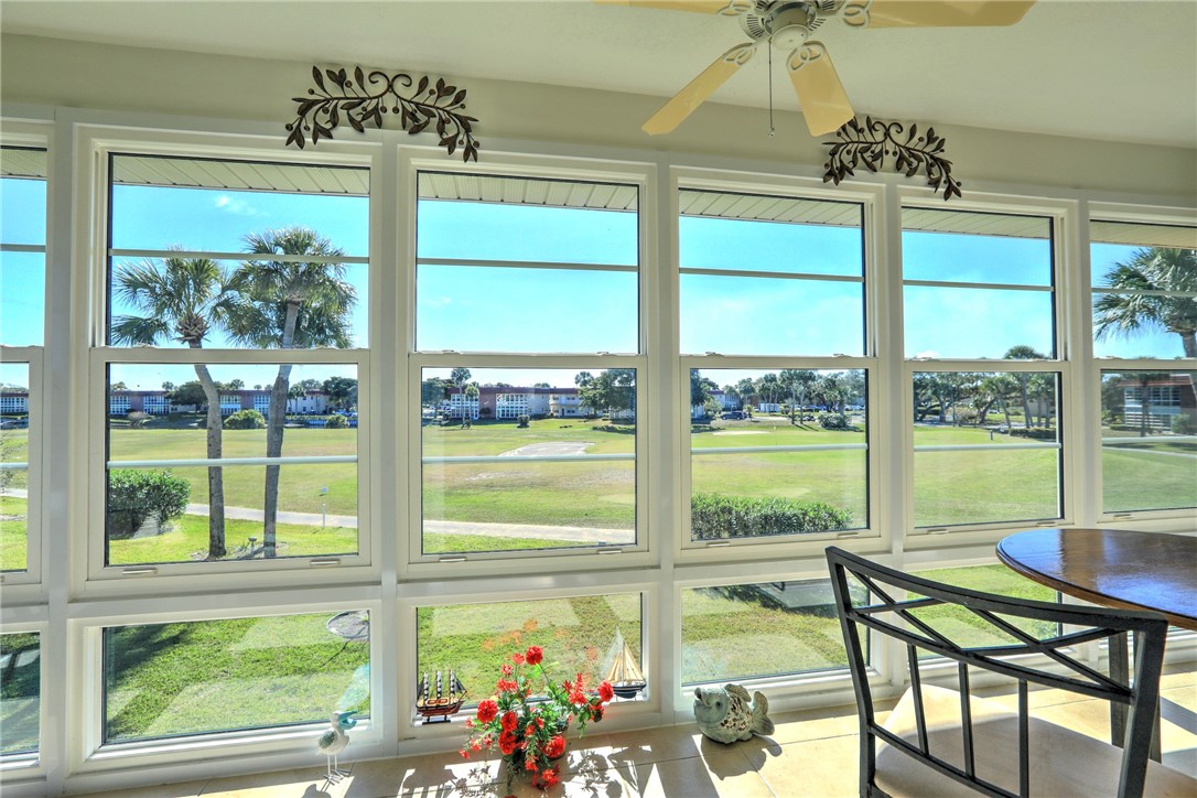 105 Spring Lake Court, Unit 207 Vero Beach, FL 32962 - Photo 23 of 34 a view of a dining room with furniture large windows and wooden floor