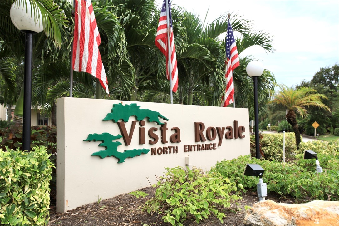 105 Spring Lake Court, Unit 207 Vero Beach, FL 32962 - Photo 26 of 34 a street sign that is sitting in front of flowers