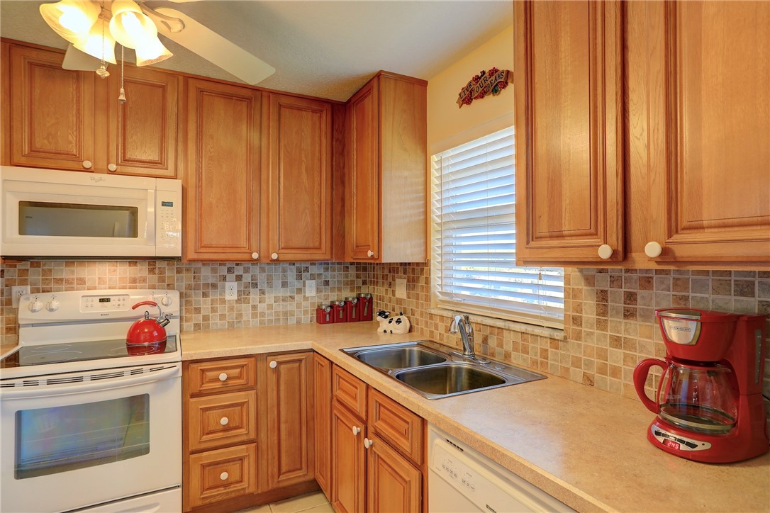 105 Spring Lake Court, Unit 207 Vero Beach, FL 32962 - Photo 5 of 34 a kitchen with stainless steel appliances a stove a sink and cabinets