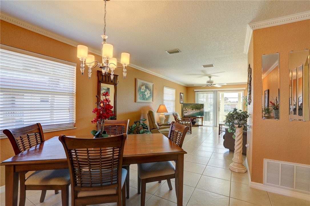 105 Spring Lake Court, Unit 207 Vero Beach, FL 32962 - Photo 8 of 34 a dining room with furniture a chandelier and window