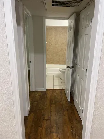 a view of a room with wooden floor and a door