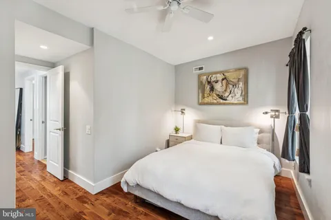 a bedroom with a bed and a painting on the wall